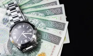 Zegarek na stosie polskich banknotów 100 zł.